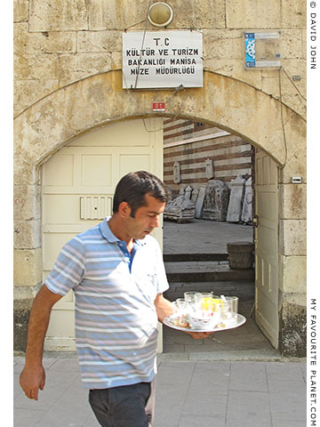 A man carrying a tray of tea glasses at the Muradaiye Medresesi in Manisa, Turkey