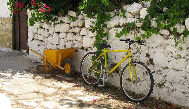 A yellow wheelbarrow and yellow bicycle in Kastellorizo, Greece at My Favourite Planet