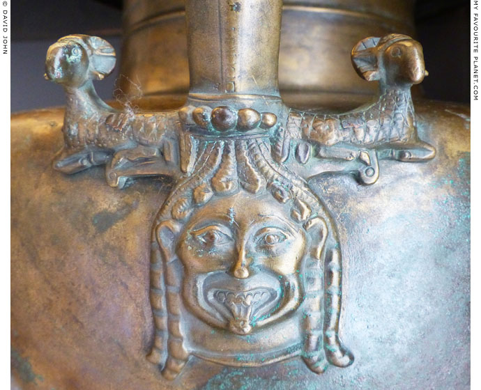 A relief of a Gorgoneion on an Archaic bronze hydria from Diasella, Elis, Greece at My Favourite Planet